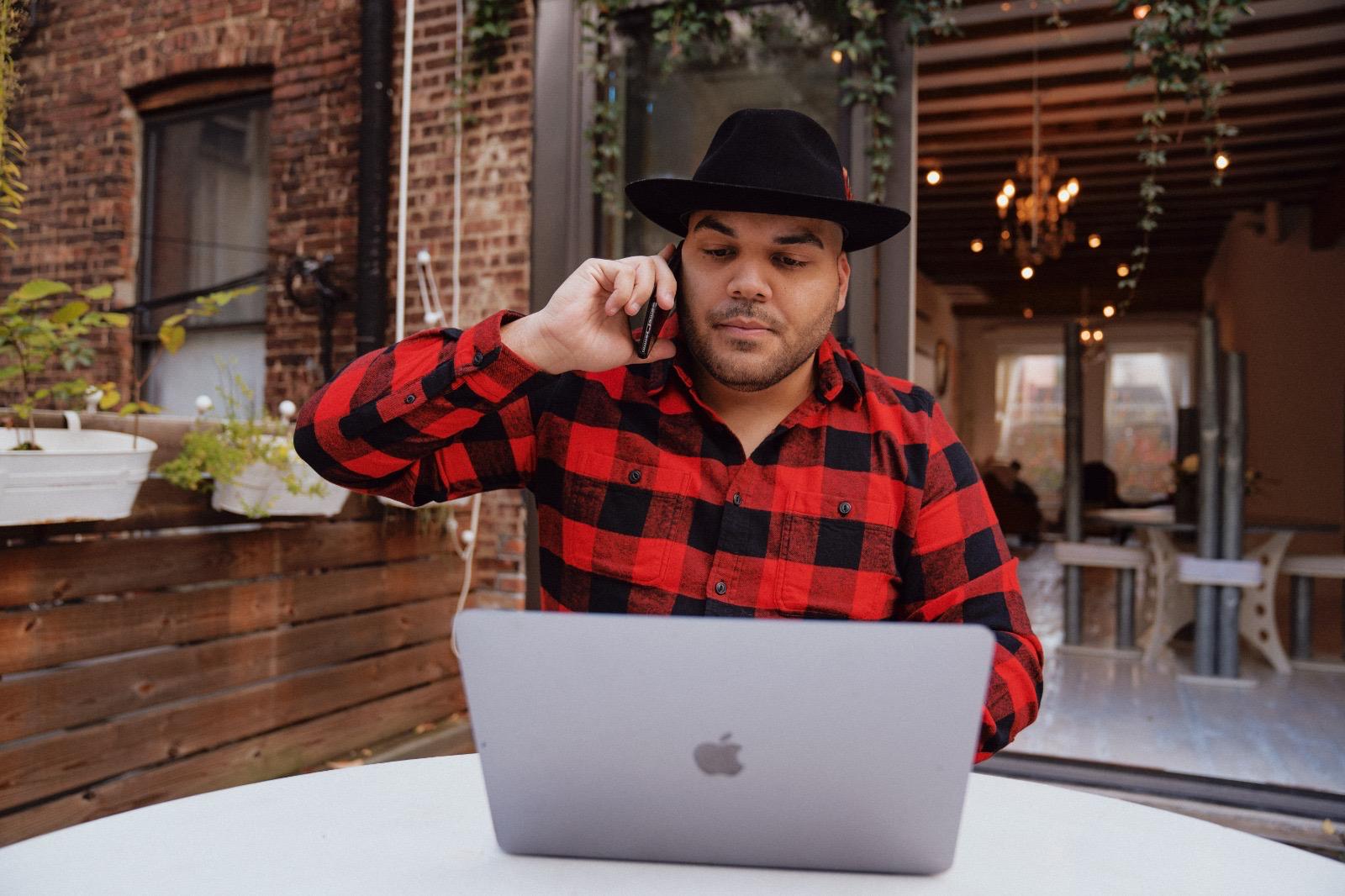 Carlos Angelucci on the phone outside a Brooklyn cafe