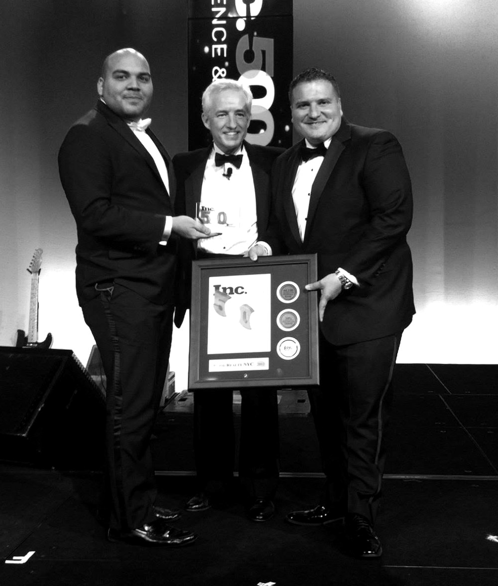 Carlos Angelucci and the Rapid Realty NYC principals accepting the Inc. 5000 award on stage