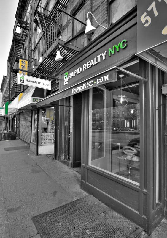 A Rapid Realty NYC storefront on a Brooklyn block, RapidNYC.com painted on the awning