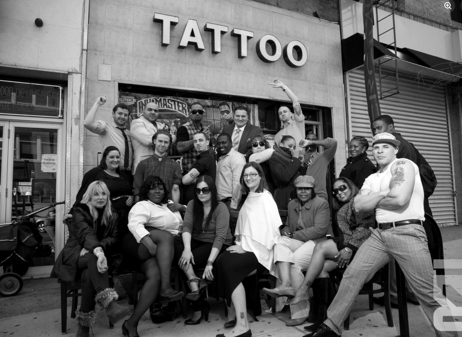 The Rapid Realty NYC team posing under a tattoo parlor sign during the tattoo campaign